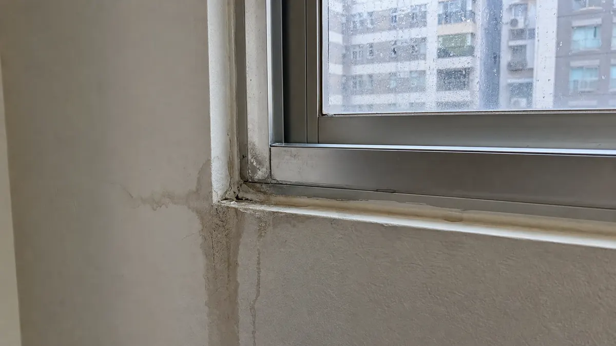 窗框邊緣與牆面交界出現滲水痕跡